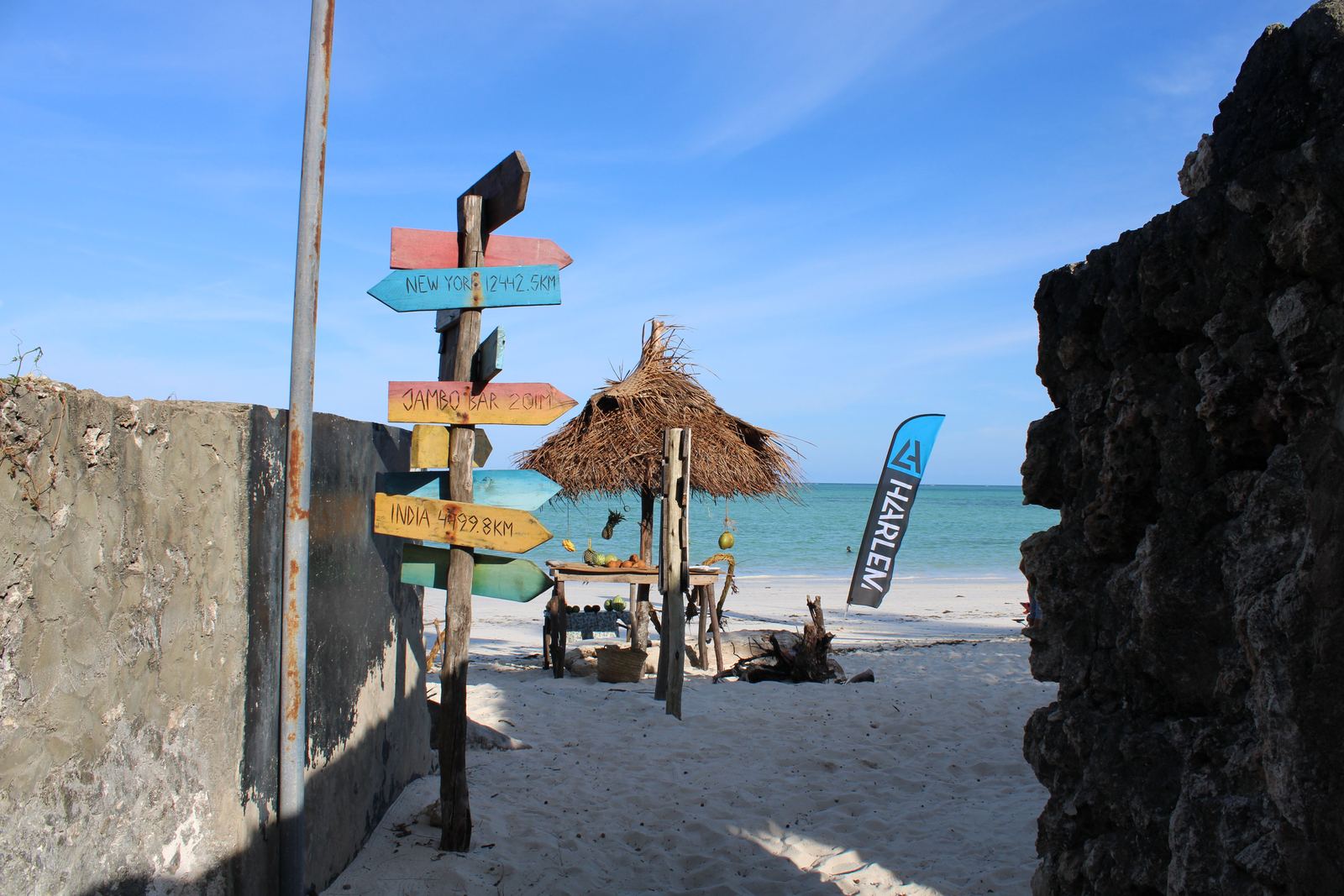 Colorful signpost and straw hut on Paje Beach, Tanzania